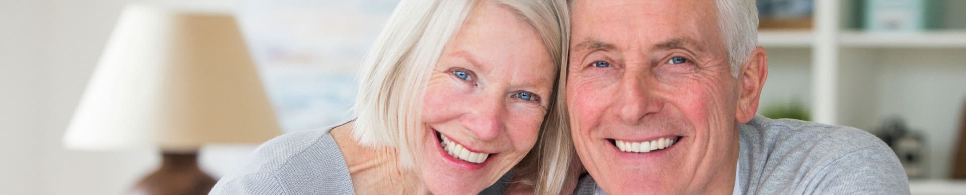 Happy mature couple smiling on Brisbane balcony.